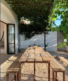 an outdoor dining area with wooden table and benches