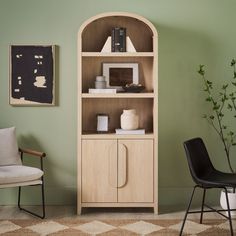 a living room with a chair and bookcase in front of a painting on the wall