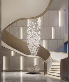 a large spiral staircase with chandelier hanging from it's sides in a modern building