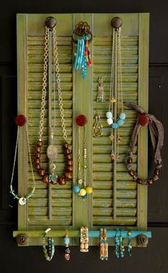 a wall mounted jewelry rack with several necklaces hanging on it's sides,