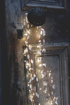 the door is decorated with white leaves and lights