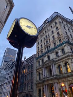 a clock on a pole in front of buildings