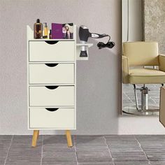 a white cabinet with drawers and hair dryer on it in front of a mirror