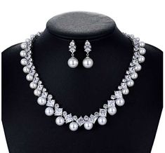 Pearl and CZ Wedding Jewelry Set Complete your elegant wedding day look with our fabulous pearl and CZ necklace and earring set. This glamorous platinum silver plated jewelry set features dazzling AAAAA quality CZ crystals in round and teardrop cuts as well as lustrous pearl beads. This luxurious jewelry set will add timeless elegance to any bridal ensemble. Size: The necklace is about 17" long and the pierced earrings are about 1" long. Color: Silver. Style: ne10130. Please allow about 3 weeks for delivery. Shipping Policy . Return Policy Silver Pearl Bridal Sets For Formal Occasions, Formal Silver Pearl Bridal Sets, Formal Silver Pearl Jewelry Sets, Silver Cubic Zirconia Pearl Necklace For Wedding, Silver Pearl Wedding Jewelry Sets, Elegant Silver Pearl Jewelry Sets, Anniversary Jewelry Sets With Pearl Drop And Cubic Zirconia, Silver Bridal Necklace With Pearl Drop And Cubic Zirconia, Silver Pearl Jewelry Sets With Pearl Chain