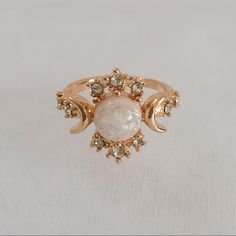 Gold Plated, White Opal (Simulated) Celestial Ring. Features The “Sun”, “Moon”, And “Stars” Represented By The Different Stones. Item Is A Size 6, New, And Unworn. Please Ask Me Any Questions You May Have Prior To Making A Purchase. Sun And Moon Engagement Rings, Engagement Rings Sun, Sun And Moon Wedding Rings, Gold Sun Ring, White Bohemian Jewelry With Sun And Moon Design, Bohemian White Jewelry With Sun And Moon Design, Adjustable White Celestial Rings, Adjustable White Jewelry With Sun And Moon Design, Adjustable White Sun And Moon Jewelry