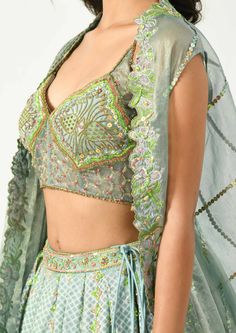 Go classy yet modern with this beautiful piece of attire. The grey-blue hued pleated lehenga has geometric and floral prints highlighted with hand and machine embroidery, the corset style blouse has multi colored sequins and beads to define the motifs, bringing an ethereal look. The key highlight, the cape has the cutwork at the border and pleats at one side making it look like a draped dupatta. Machine Embroidery Lehenga, Designer Hand Embellished Multicolor Choli, Designer Multicolor Hand Embellished Choli, Multicolor Hand Embellished Designer Choli, Designer Sets With Intricate Embroidery For Party, Multicolor Hand Embellished Sets For Reception, Festive Multicolor Hand Embellished Choli, Multicolor Hand Embellished Lehenga For Party, Hand Embellished Multicolor Anarkali Sets