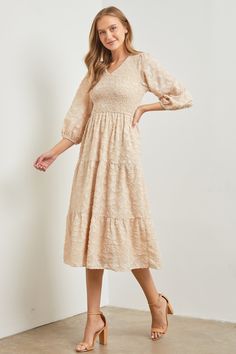 Textured fabric tan dress with stretchy smocked bodice,v-neckline, elastic waistband, elastic 3/4 sleeves, tiered skirt and side pockets. Self and Lining 100% Polyester Hand wash in cold. Aprox. measurements in inches: S:Length-47.5 |Bust-29 |Waist-27 M:Length-47.5 |Bust-32 |Waist-30 L:Length-48 |Bust-35 |Waist-33 XL:Length-49 |Bust-37 |Waist-35 modest dresses, modest dress, modest midi, modest maxi, modest fashion, modest trendy dresses, modest boutique, modest attire, modest clothing, modest t Beige Midi Dress With Gathered Waist, Modest Midi Dress With Gathered Waist, Beige Tiered Midi Dress, Modest Midi Dress With Elastic Sleeves, Beige Midi Dress With Elastic Waistband, Beige Smocked Bodice Midi Dress, Beige Midi Dress With Smocked Bodice, Modest Midi Dress With V-neck And Smocked Back, Beige Midi Dress With 3/4 Sleeves For Spring