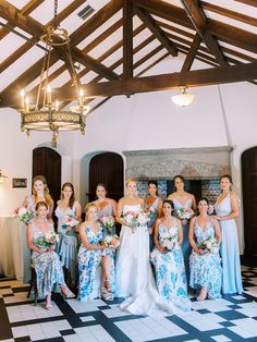 a group of women standing next to each other in front of a chandelier