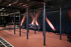 an empty gym with equipment in the middle and lights on either side of the room