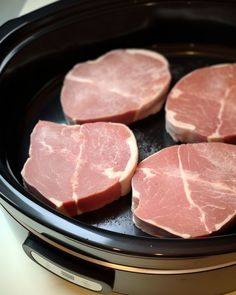 four pieces of raw meat in a slow cooker