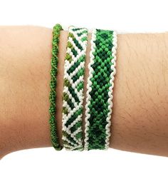 a person's arm with three bracelets on top of each other, one is green and the other is white