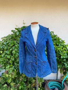 Vintage 1970's denim blazer jacket by Land Lubber. Buttons down the front with hand pockets at the hips.  Fitted style with a back center vent.  Epaulettes with buttons at the shoulders.  Great vintage condition!  The buttons have lost color.  See pictures. label: The Original and Authentic Landlubber fabric:  feels like all cotton with no stretch size:  no size listed.  Extra small is just an estimate. Please check measurements for an accurate fit.  Questions are welcome!  For reference, my dress form measures 36x24x35 and it was a nice fit. jacket was measured across the front side lying flat underarm to underarm 18" waist 15" length 28" shoulder 15" sleeve from shoulder seam 24 1/2" Fitted Medium Wash Single Breasted Blazer, Fitted Single Breasted Medium Wash Blazer, Fitted Single-breasted Medium Wash Blazer, Fitted Single-breasted Blazer In Medium Wash, Retro Spring Denim Jacket With Patch Pockets, Fitted Denim Blazer With Patch Pockets, Retro Denim Jacket For Spring Workwear, Retro Fitted Button-up Denim Jacket, Retro Fitted Denim Jacket With Button Closure