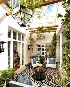 an outdoor living area with white furniture and plants