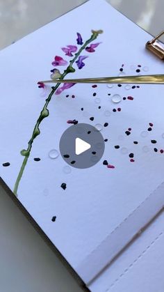 a piece of paper with flowers on it next to a pen and ink rollers