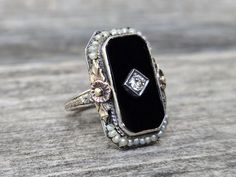 Vintage 14K Black Onyx Diamond & Sea Pearls Ring. Beautiful black onyx with a sparkling diamond at the center set on antique design white gold setting with sea pearls and rose gold flowers with yellow gold leaves. It is a gorgeous unique piece to treasure!  Please notice this is an antique ring with original sea pearls that I can see some wears on the pearls and lose of luster.  Size 4 1/2 Weights 5.7g Onyx measures 18.5mm x 10mm Center diamond 2.5mm  Marked: 14K This is an estate item that was Rose Gold Flowers, Pearls Ring, Rose Gold Flower, White Gold Set, Antique Ring, Etsy Gold Ring, Teenage Fashion, Dope Jewelry, Sparkling Diamond