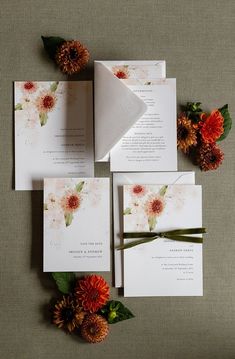 the wedding stationery is laid out with flowers