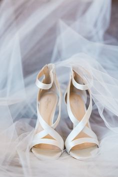 the bride's shoes are covered in white fabric and tulle veils on her wedding day