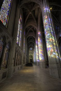 sunlight streams through the stained glass windows in a cathedral