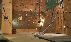 an indoor climbing wall with chains and lights