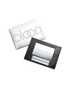 a black and white photo frame sitting next to a pillow with the word bloom on it