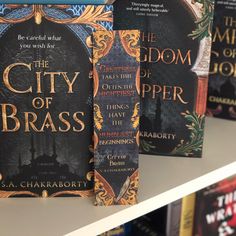 the city of brass books are lined up on a shelf