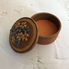 a wooden container filled with lots of nuts on top of a white table covered in snow