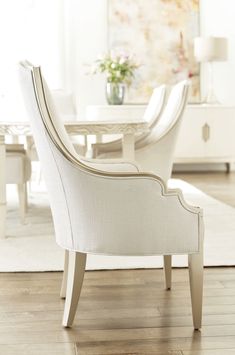 a white dining room set with chairs and a table