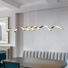 a dining room table and chairs with lights hanging from the ceiling