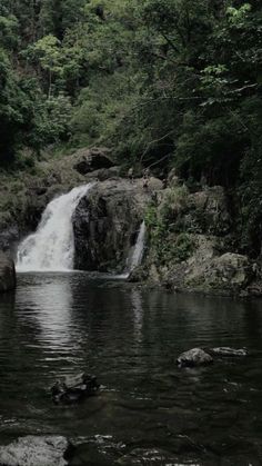 a small waterfall in the middle of a forest