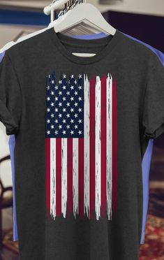 a t - shirt with the american flag painted on it is hanging in a store