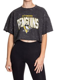 Woman standing in front of a white background wearing an oversized, black, acid wash crop top - featuring a Pittsburgh Penguins logo in the center of the shirt. Sporty Acid Wash Soft-washed Tops, Sporty Acid Wash Cotton Top, Sporty Black Washed Top, Soft-washed Cotton Cropped Crop Top, Soft-washed Cotton Crop Top, Spring Season Soft-washed Cropped Top, Spring Soft-washed Cropped Crop Top, Sporty Acid Wash Distressed Top, Sporty Distressed Tops For Spring