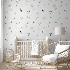 a baby's room with floral wallpaper and rocking chair in front of the crib