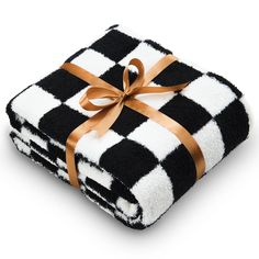 a black and white checkered blanket wrapped in gold ribbon