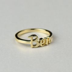 Perfect for new mothers and babies, this solid gold name text script ring is completely personalized with whatever text you want. Available in 14k, 18k yellow, rose, white gold & platinum--just choose your desired metal from the drop-down menu before checkout. HOW TO ORDER: Please specify the text in the order notes during checkout. Details: * Default size is approx. 7mm tall for the text, and the band is 1.8mm x 1mm. Contact us if you want different dimensions. * We can do the finish as mat Custom Name Adjustable Initial Ring In 14k Gold, Adjustable 14k Gold Initial Ring With Custom Name, Personalized Nameplate Ring For Promise, Personalized Yellow Gold Initial Promise Ring, Personalized Engraved Nameplate Ring For Promise, 14k Gold Custom Name Engraved Ring For Promise, 14k Gold Engraved Ring With Custom Name For Promise, Custom Name 14k Gold Engraved Promise Ring, Custom Name Engraved 14k Gold Promise Ring