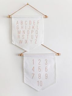 two white wall hangings with gold numbers on them