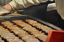 sausages being cooked on the grill at a restaurant