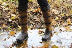 a person standing in the rain wearing brown boots