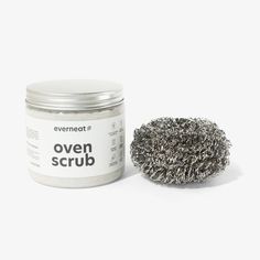 an open scrub sits next to a jar of silver shavings on a white background