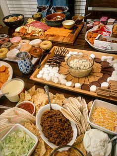 a table filled with different types of food and dips on trays next to each other