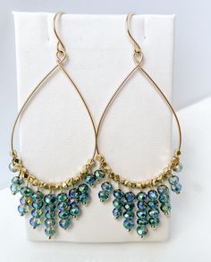 Are you looking for a unique and beautifully handcrafted accessory? Look no further than these handmade Gold Beaded Teardrop Hoop Earrings! As a single artisan handmade business based in California, I take pride in creating each pair of earrings with the utmost care and attention to detail.  Measuring approximately 3 inches long (including ear wire) and 1.25 inches wide, each hoop is beaded with multifaceted cut beads on 14k gold-filled wire.  Each ear wire is also handmade of 14k gold-filled.  The 14k gold-filled is manufactured in the USA.  Gold-filled is of higher quality and will last for years without tarnishing. I believe in the quality of my work, which is why I offer a Happiness Guarantee. If for any reason you're not completely satisfied with your purchase, you can return it withi Teardrop Hoop Earrings, Hoop Earrings Handmade, Blueish Green, Jewelry Making Classes, Statement Hoop Earrings, Artisan Gift, Wire Work Jewelry, Handcrafted Accessories, Earrings Inspiration