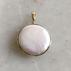 ITEM DESCRIPTION: >> The Pendant is made from Solid 14K Yellow Gold. Gemstone used is absolutely natural and ethically sourced. >> Natural Flat Cut mop  in round shape and bezel setting is studded on it with utmost precision.  >> This is a minimalist design and is absolutely hassle-free and everyday jewelry.  Gem:  Pearl  Gem size: 20mm Round Gem weight: 3.42  carats Gold purity: 14K (58.33% approx.) Gold weight: 0.60 grams  Gross weight: 4.02 grams The Gold purity is guaranteed and it comes with authentic 14K gold hallmark. Since this Pendant are handmade, It is Nickel/Lead FREE.  CUSTOMISATION: --> Earrings of the same design is also available on my Etsy Shop. --> You can choose your own gemstone. Kindly drop a message for more options. CUSTOMER SUPPORT: We are available 24/7 to respond Round Pearl Pendant Jewelry From Mother Of Pearl, Round Mother Of Pearl Pendant Jewelry, White Polished Finish Round Pendant Jewelry, Round Pearl Pendant Jewelry, Polished Mother Of Pearl Pendant Jewelry, Pearl Drop Medallion Jewelry Gift, Anniversary Jewelry With Pearl Pendant Medallion, Pearl Pendant Medallion Jewelry For Anniversary, Pearl Medallion Pendant Jewelry In Mother Of Pearl