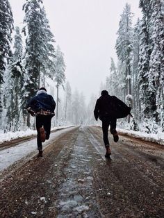 two people running down a road in the snow