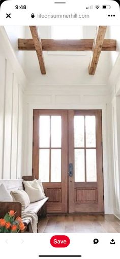 a living room filled with furniture and wooden beams on top of the ceiling next to a door