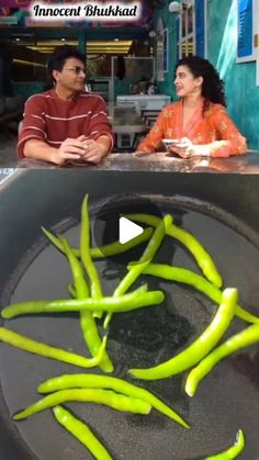 two people sitting at a table with green beans in a pan and one person standing behind them