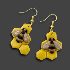 a pair of earrings with a bee on it