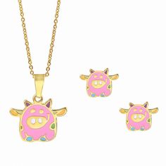 two necklaces and a pendant with a pink cow on it