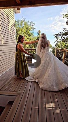 the bride is getting ready to walk down the wooden deck for her wedding ceremony at home