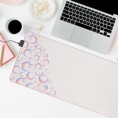 a laptop computer sitting on top of a desk next to a mouse pad and keyboard