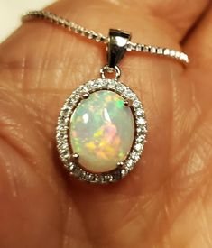 "Very Pretty Natural Opal Halo Necklace, Dainty, But Colorful, 8x10mm Ethiopian Opal, See Fire On Video! We Have More Than One, Stones Vary Slightly, Quality Does Not. You May Ask To See Before Purchase. 925 Sterling Silver Pendant, Rhodium Plated, Crystal Halo, 18\" Sterling Silver Chain. Gift Box Included. Great Gift!" Oval White Necklace Stamped 925, Handmade Opal Round Pendant Necklace, Silver Oval Necklace With Bail, Opal Diamond Halo Pendant, Unique Opal Round Pendant Necklace, Sterling Silver Necklace With Bail As A Gift, Opal Gemstone Round Pendant Necklace, Nickel-free Opal Pendant Jewelry, Halo Necklace