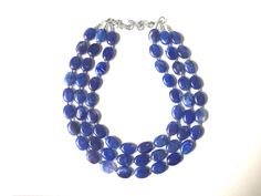 "A great statement piece! Three of layers of royal blue oval Beads that are hand made and swirled so no 2 beads are exactly alike. Each acrylic bead is spaced with a small silver bead to give this a polished look! Approximately 17 inches at shortest strand, with a 4 inch chain and silver plated lobster clasp.I can also make this in a single strand for $13.90. Convo me! Earrings are 1.25\" drop. These make great, affordable bridesmaid necklaces for weddings as well. Ask me about bulk discounts! N Blue Gemstone Beads Necklaces For Party, Blue Gemstone Beads Necklace For Party, Blue Wedding Bridesmaid, Dark Blue Necklace, Bridesmaid Necklaces, Jewlery Necklace, Royal Blue Wedding, Chunky Statement Necklace, Bubble Necklaces